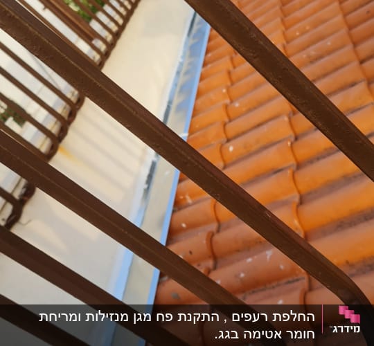 גג רעפים כתומים עם מעקה מתכת חום